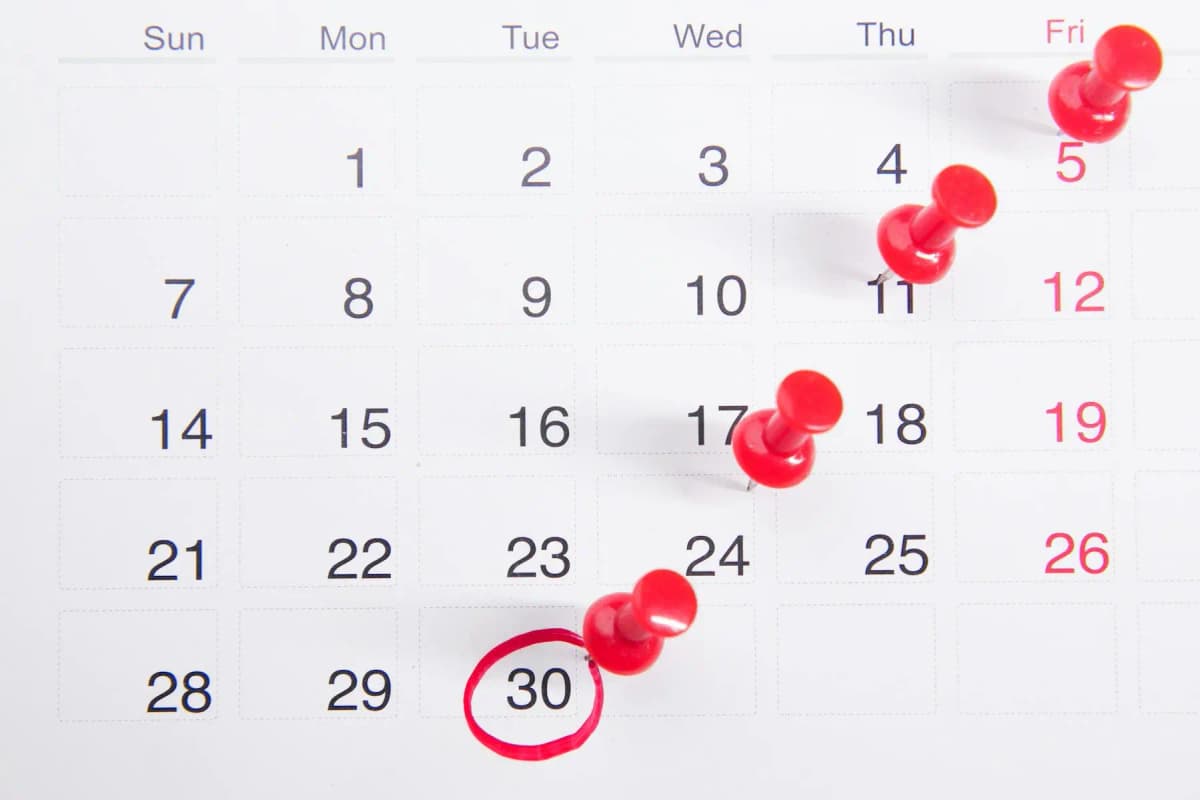 Monthly calendar with red pins marking significant birthdays and age milestones including 10000 days alive
